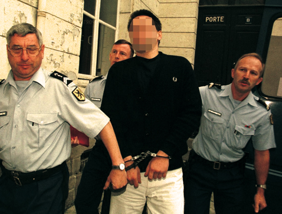 Germany's hooligan  Markus Warnecke (C) arrives flanked by police at the Douai court September 1st. ..