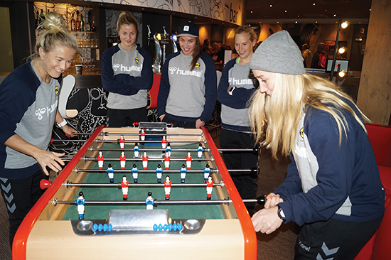 Da to busslaster med spanske pensjonister skapte kø for å ta heisen opp til hotellrommet i 6. etasje, slo Lene Mykjåland (t.v) og Lily Karlsrud ihjel tiden med å spille «babyfoot», som det heter i Frankrike. Ingrid Marie Spord (bak t.v.) fikk oppfylt drømmen om å spille på Norges beste lag da hun ble hentet fra Sandviken i juli.